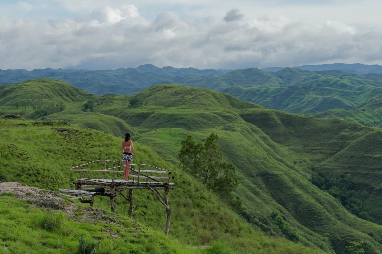 A traveller at a lookout above green hills in the Tanarara and Hiliwuku area