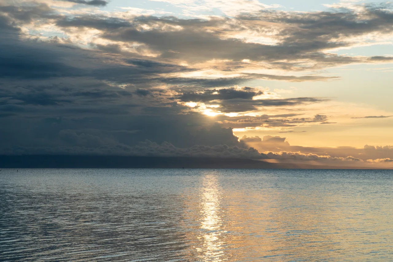 Sunlight breaking through clouds above the sea at Laipori