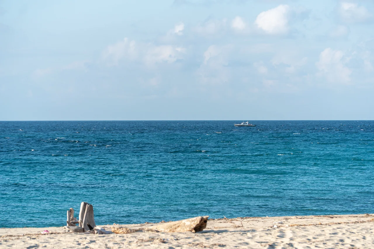 Pale sand and clear blue water at Laki Beach