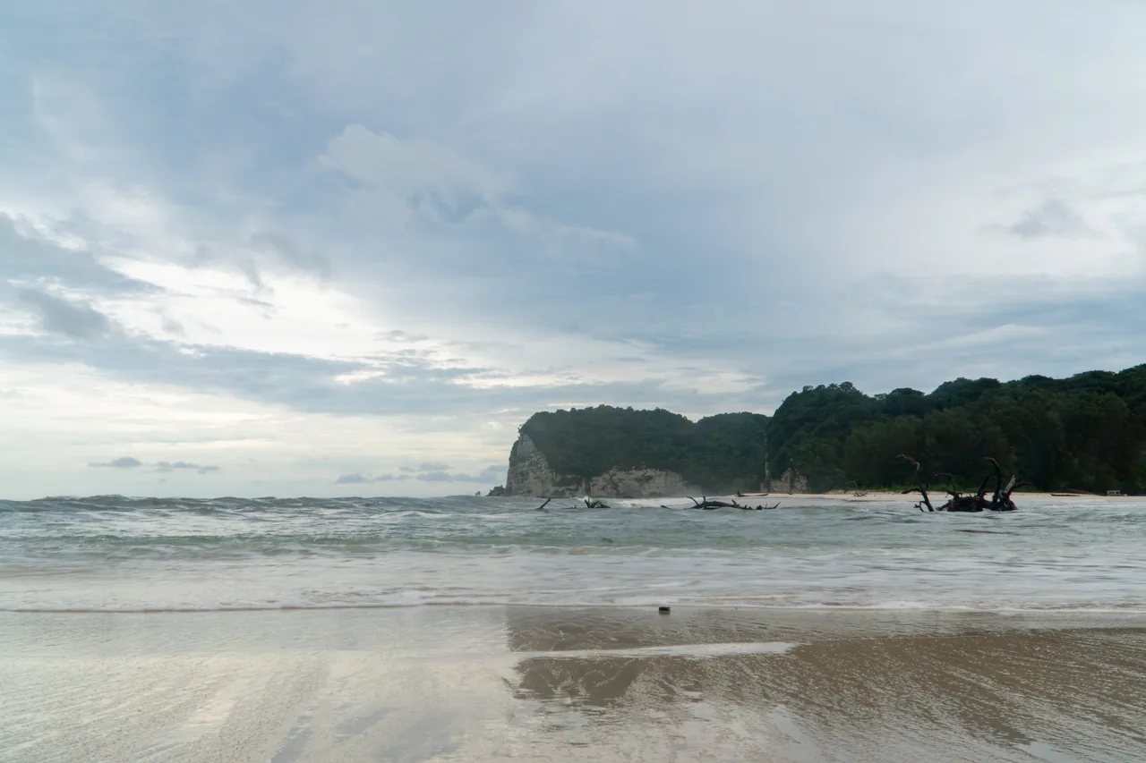 The broad sandy bay and green headlands at Tarimbang
