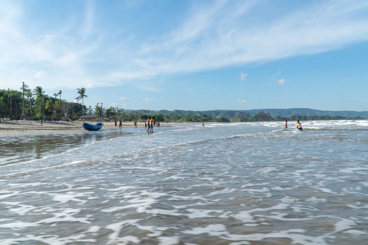 Waves washing onto the broad shoreline at Watu Parunu